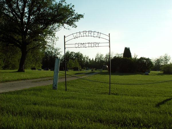 Cemetery entrance sign with green prairie landscape