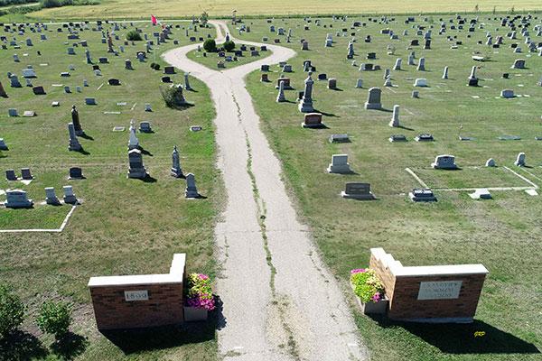 Aerial view of cemetery with brick entrance and winding path